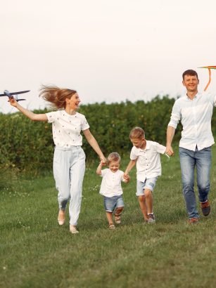 Rodzina chodzi po polu i bawi się zabawkowym samolotem