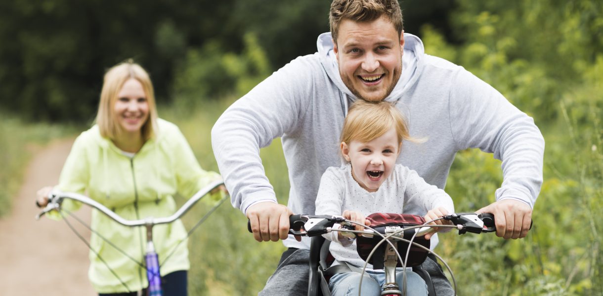 Happy family with bikes on forest road