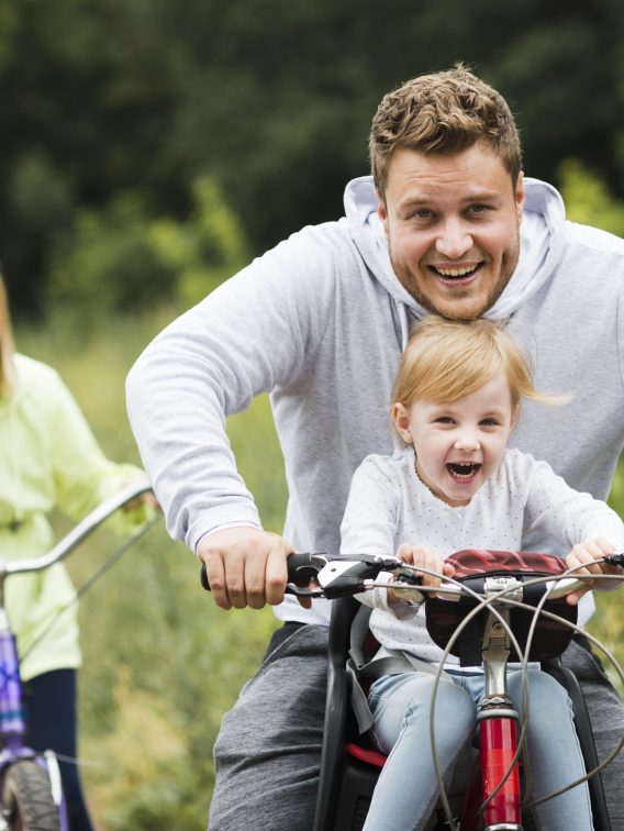 Happy family with bikes on forest road